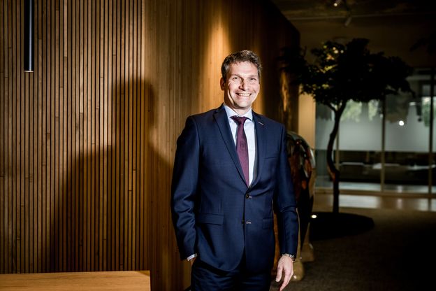 Een man in pak poseert voor een foto