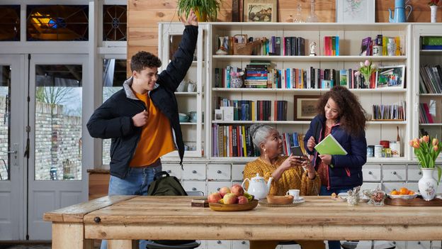 kinderen kijken bij oudere vrouw op telefoon